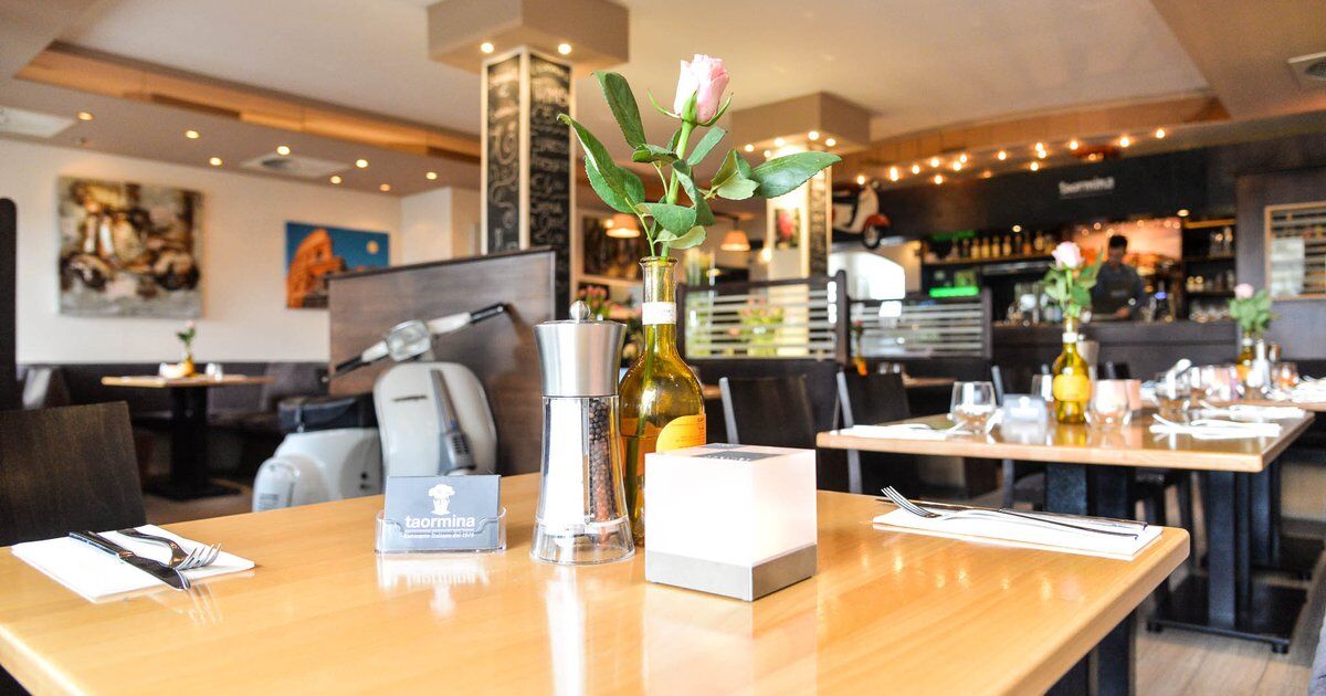 Gedeckter Tisch, im Hintergrund Vespa und Bar