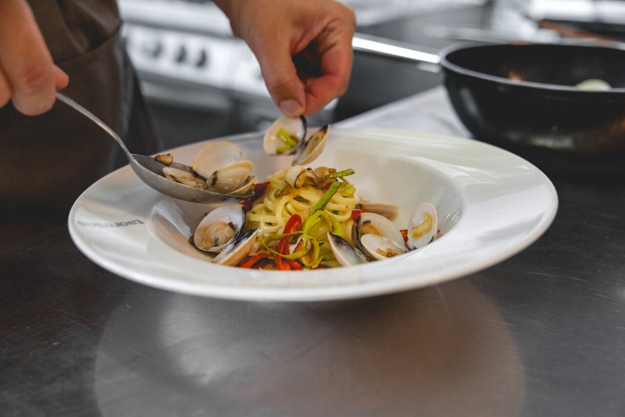 Koch richtet im Ristorante Taormina ein Gericht mit Venusmuscheln an