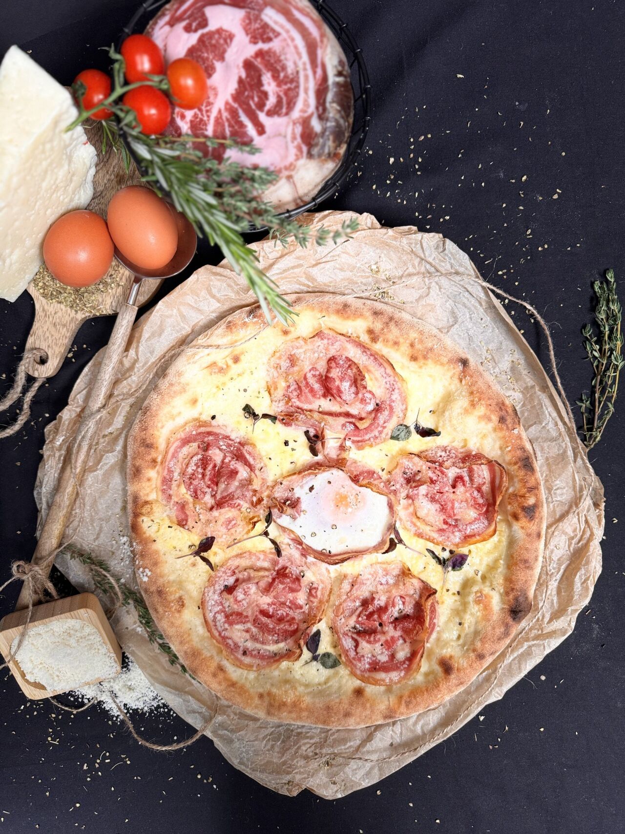 Carbonara pizza with guanciale and egg on a dark background